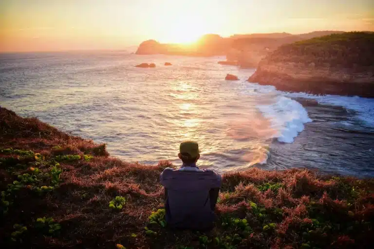 MIndfullness mediation en guide til at komme i gang. her sidder en mand og mediterer ud over flot landskab og solnedgang