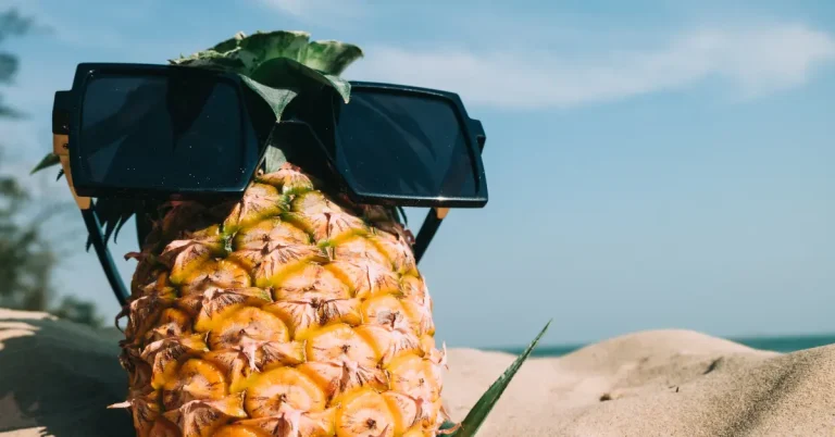Her ses en ananas på en strand og viser visuelt hvad ananas gør ved mænd