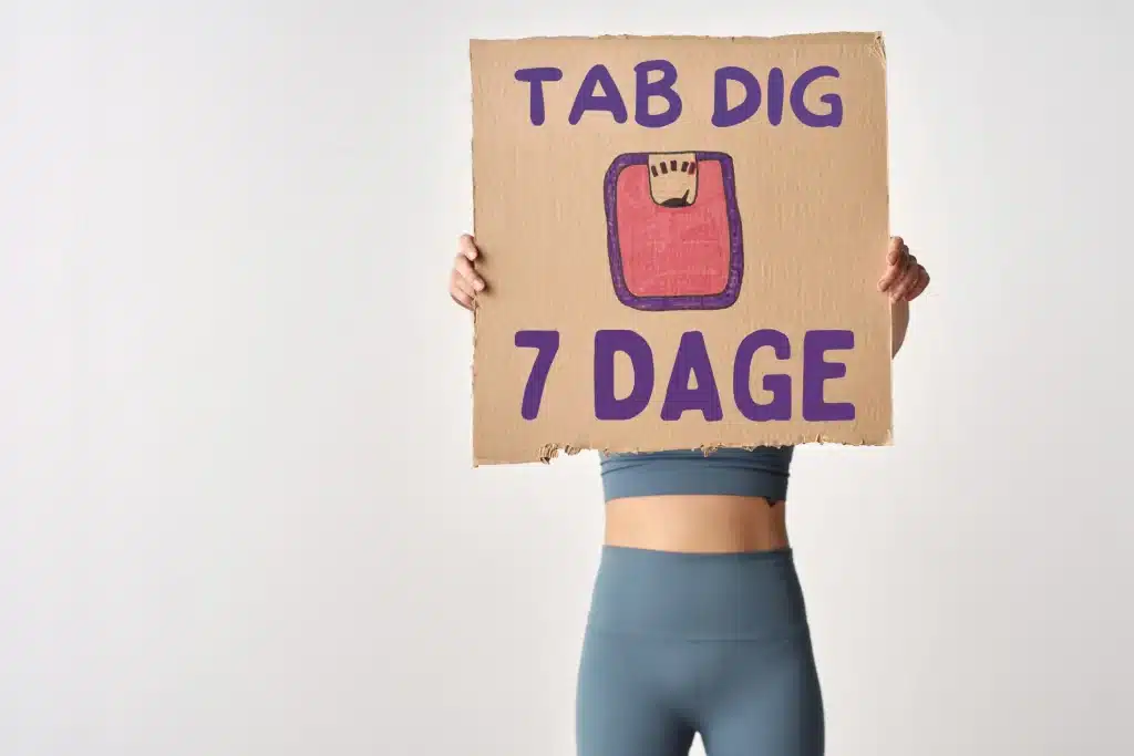 Tab dig på 7 dage. Kvinde står med tegn i hånden.