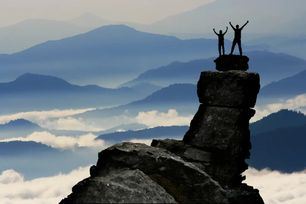 Billede af mænd der har selvtillid efter at have bestiget en bjergtop