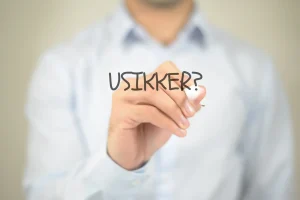 Billede af en mand der skriver usikker på et vindue
