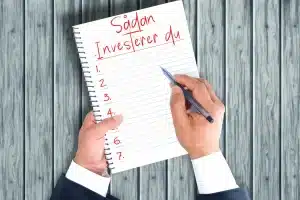 Billede af mand der tager noter til: Sådan investerer du