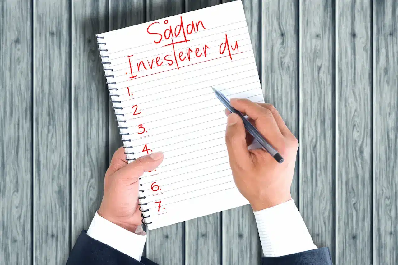 Billede af mand der tager noter til: Sådan investerer du