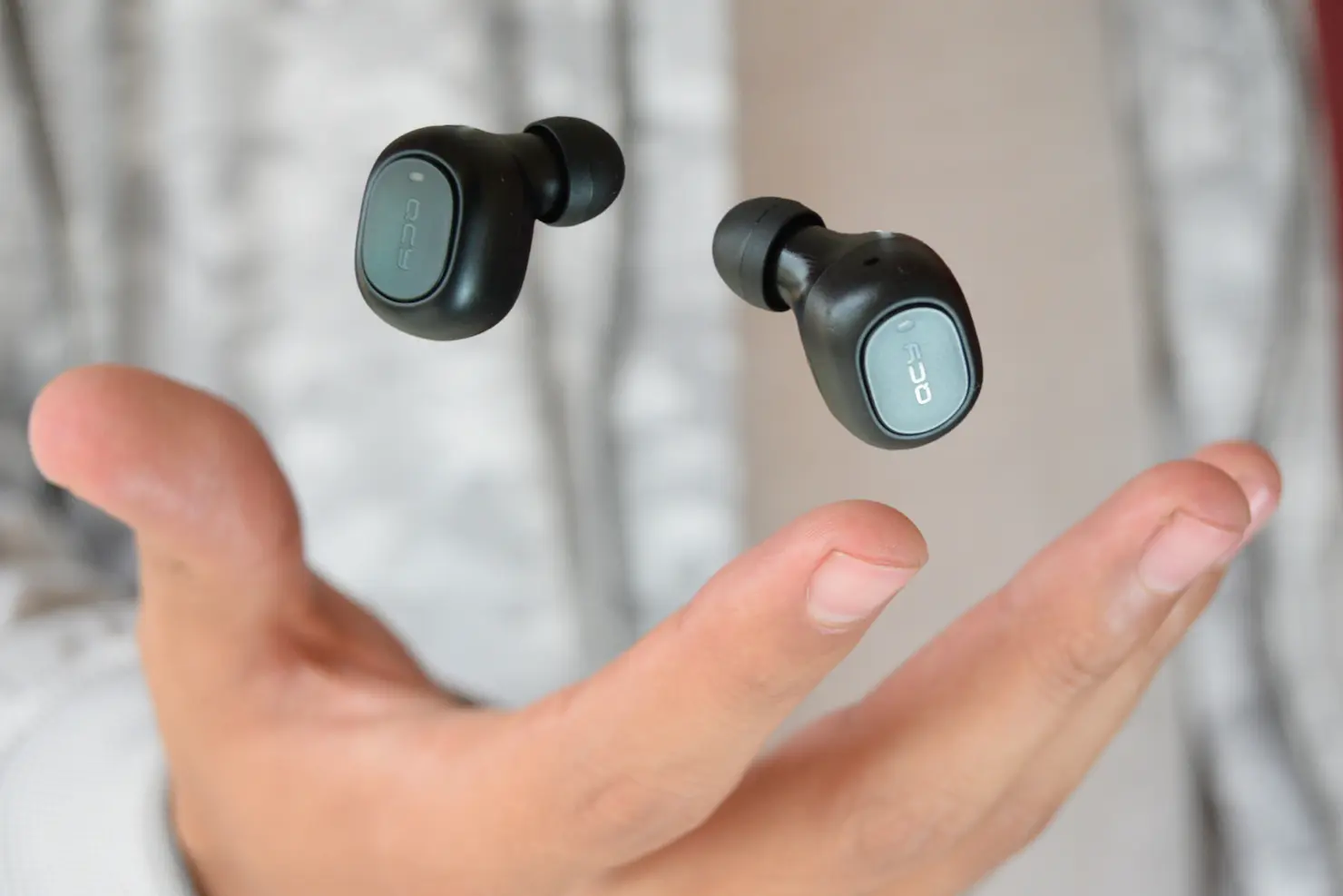 Bilede af man der kaster in ear buds hovedtelefoner op i luften